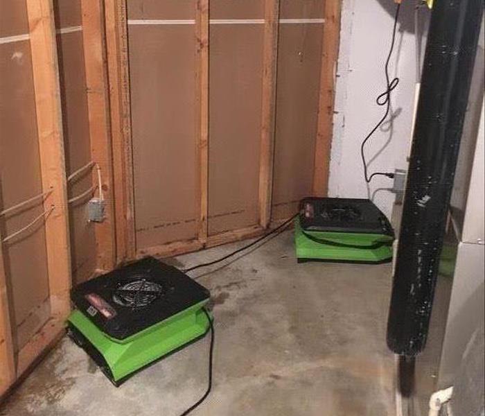 Green air movers on a concrete floor. 