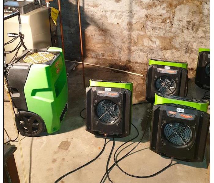 Green air movers and scrubbers in a dirty room. 